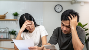 Younger couple appearing stressed over tax forms